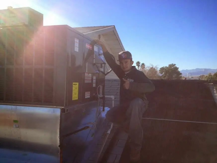 HVAC technician performing Boiler Repair on a rooftop unit in Cottage Grove